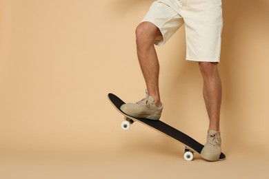 Photo of Man with skateboard on beige background, closeup. Space for text