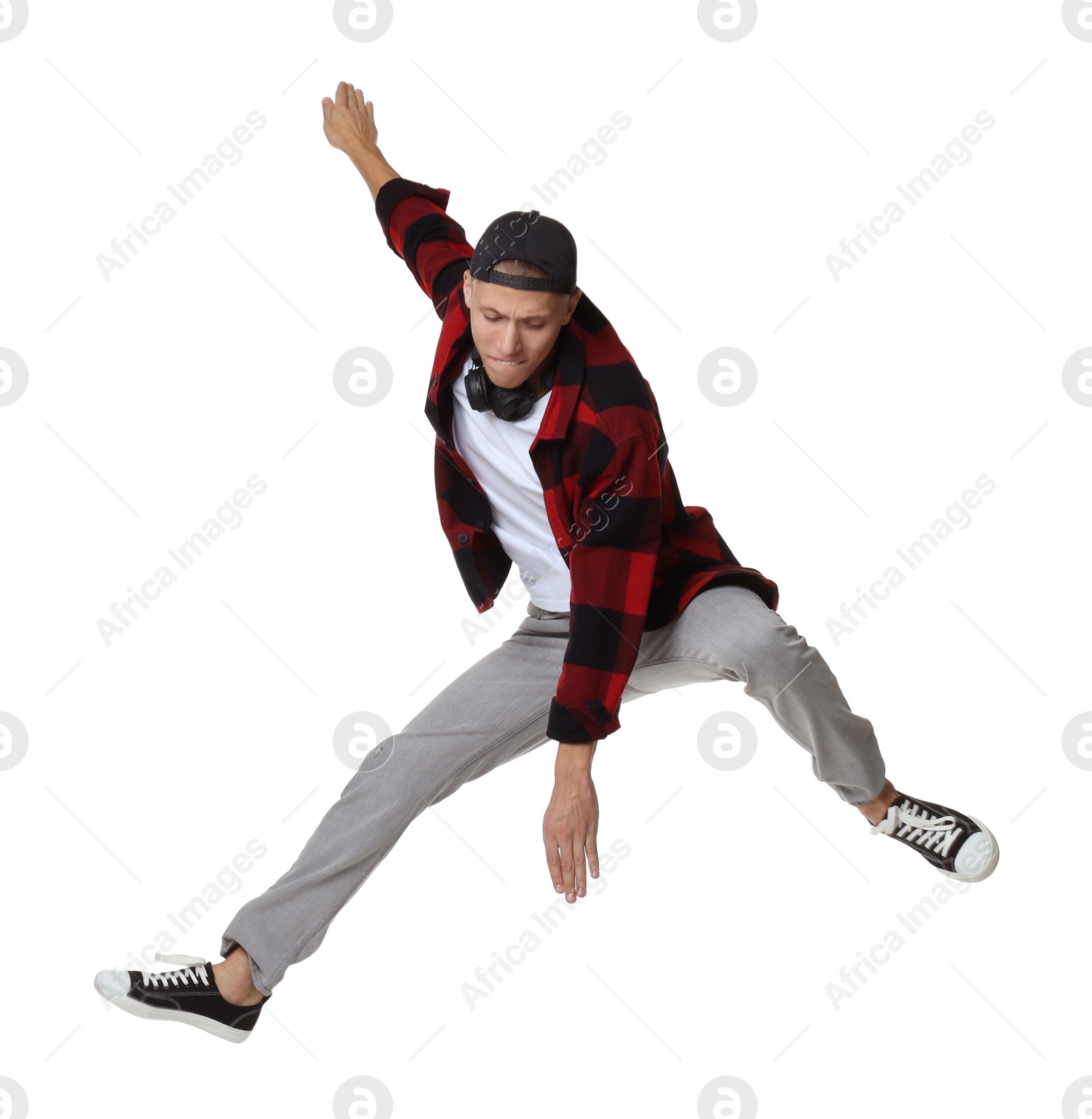 Photo of Handsome young skater jumping on white background