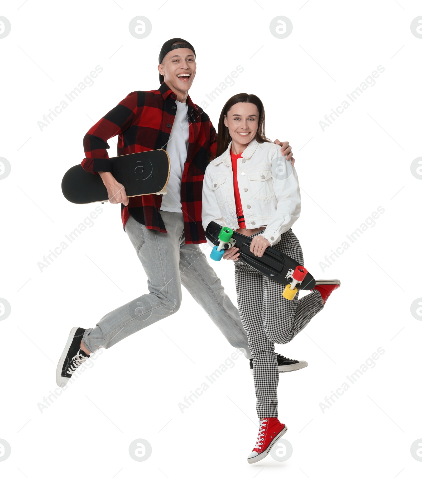 Photo of Happy friends jumping with skateboards on white background