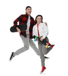 Photo of Happy friends jumping with skateboards on white background