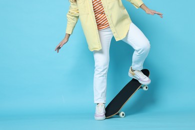 Photo of Woman with skateboard on light blue background, closeup. Space for text