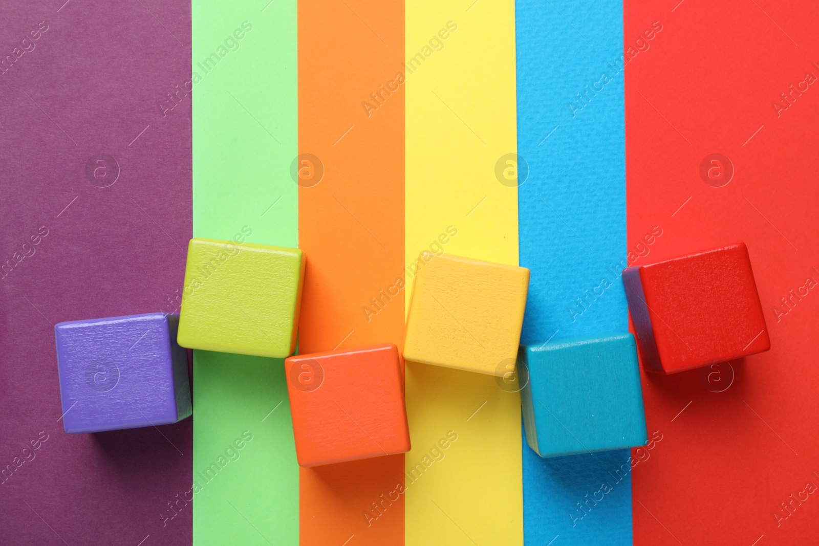 Photo of Colorful cubes on color background, flat lay