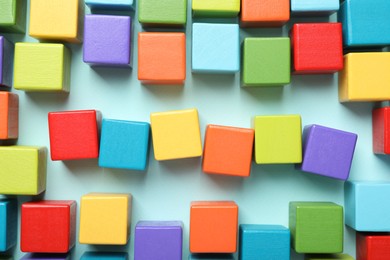 Photo of Colorful cubes on light blue background, flat lay