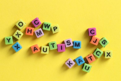 Photo of Word Autism made with colorful cubes on yellow background, flat lay