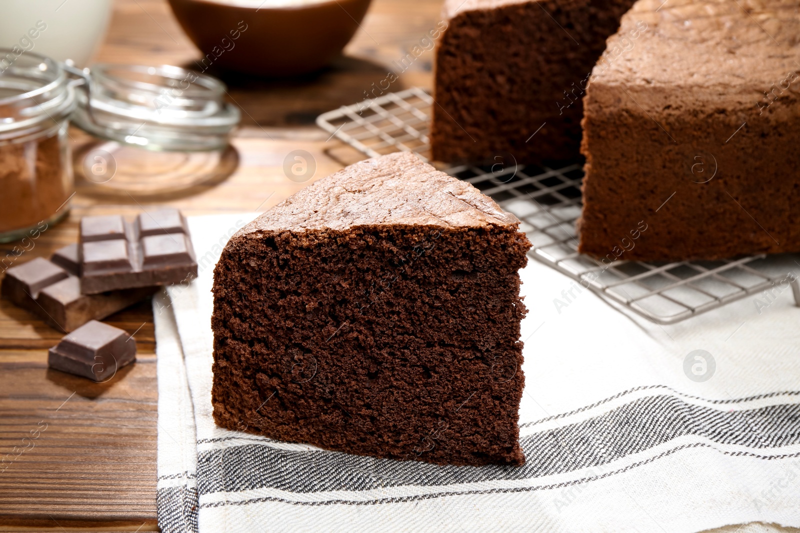 Photo of Piece of tasty chocolate sponge cake on wooden table, closeup