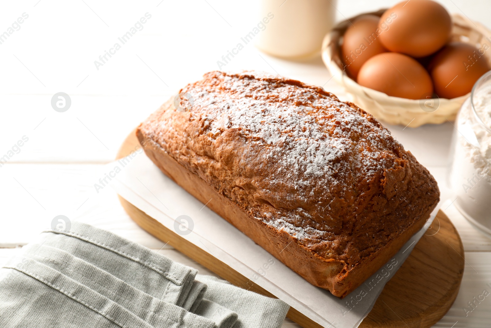 Photo of Tasty sponge cake with ingredients on white table