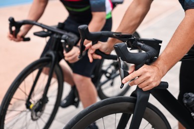 Photo of Athletic people with bicycles outdoors, closeup view