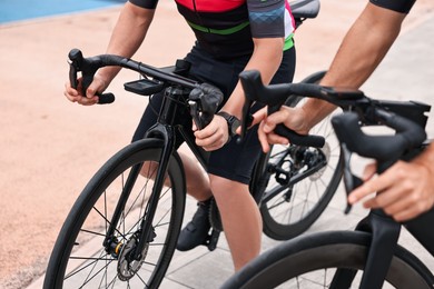 Photo of Athletic people with bicycles outdoors, closeup view