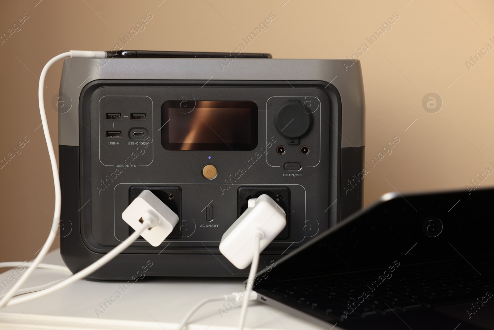 Photo of Devices charging from portable power station on nightstand indoors