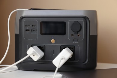 Photo of Devices charging from portable power station on nightstand indoors