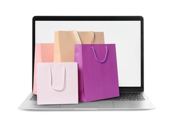 Image of Laptop with shopping bags isolated on white. Concept of online shopping, purchase via internet