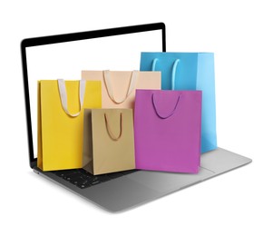 Image of Laptop with shopping bags isolated on white. Concept of online shopping, purchase via internet