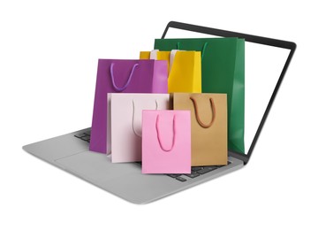 Image of Laptop with shopping bags isolated on white. Concept of online shopping, purchase via internet