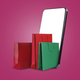 Image of Mobile phone with shopping bags on violet red background. Concept of online shopping, purchase via internet