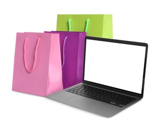 Image of Laptop and shopping bags isolated on white. Concept of online shopping, purchase via internet