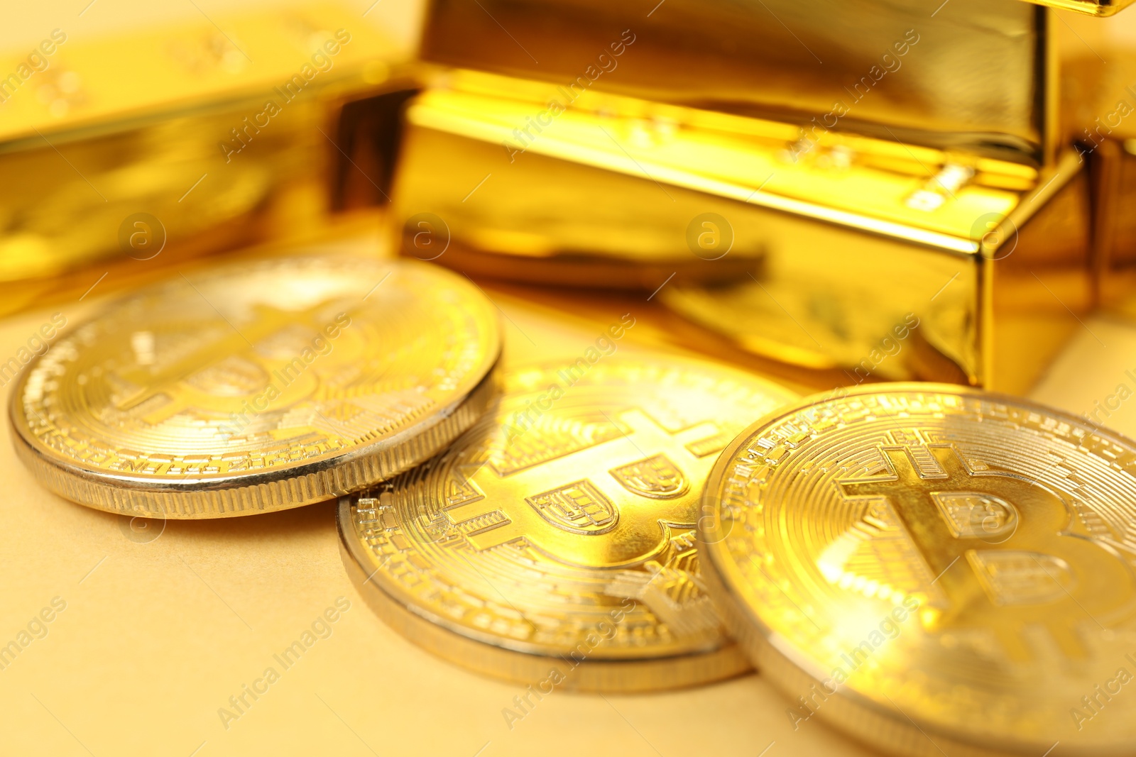 Photo of Gold bars and coins on golden background, closeup