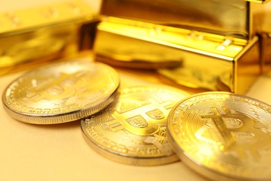 Photo of Gold bars and coins on golden background, closeup