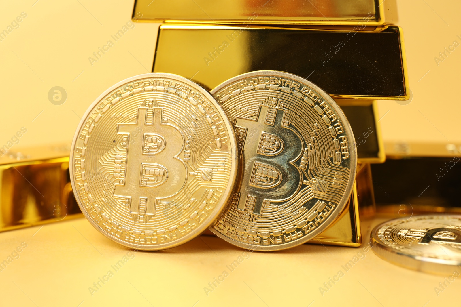 Photo of Gold bars and coins on golden background, closeup