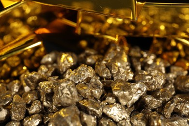 Photo of Gold nuggets and bars as background, closeup