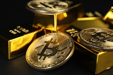 Photo of Gold bars and coins on black table, closeup