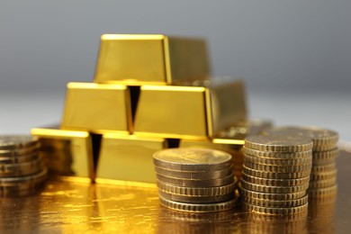 Photo of Gold bars and coins on table, closeup