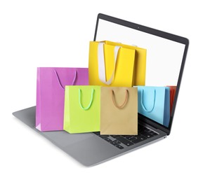 Image of Laptop with shopping bags isolated on white. Concept of online shopping, purchase via internet