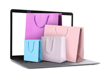 Image of Laptop with shopping bags isolated on white. Concept of online shopping, purchase via internet