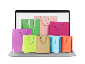 Image of Laptop with shopping bags isolated on white. Concept of online shopping, purchase via internet