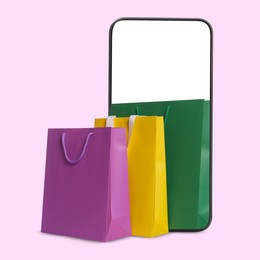 Image of Mobile phone with shopping bags on pink background. Concept of online shopping, purchase via internet