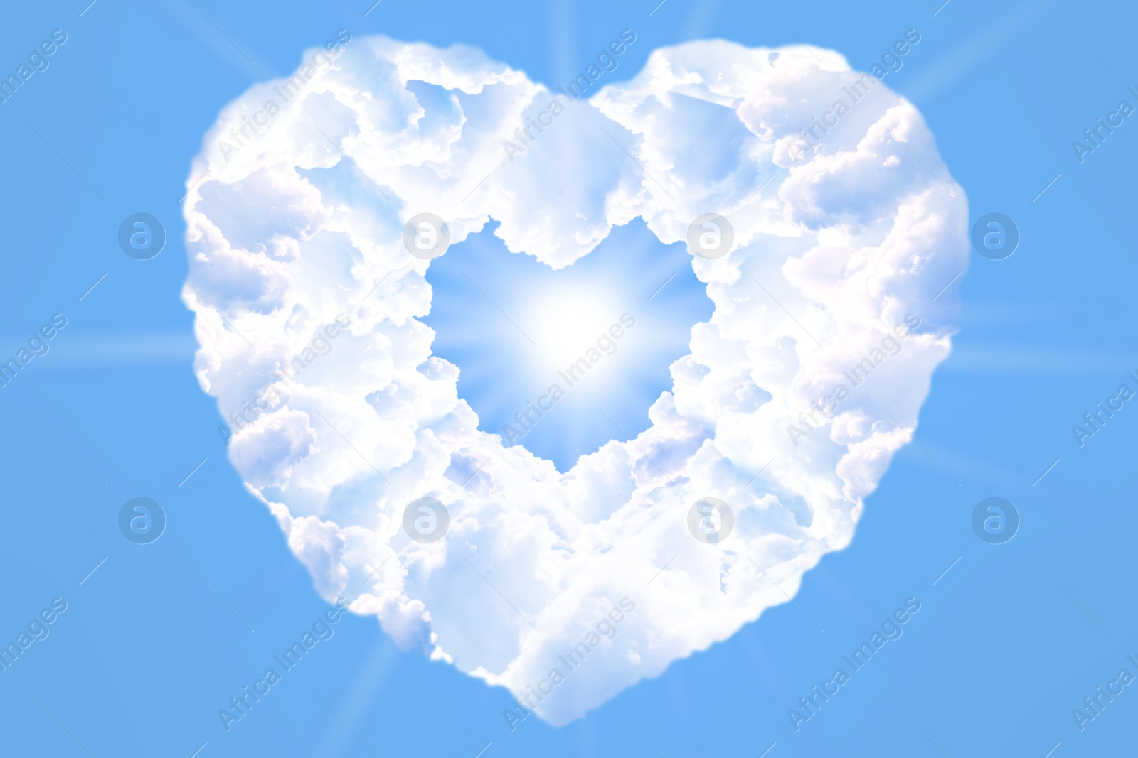 Image of Bright light shining through heart made of clouds in blue sky. Love of God, concept