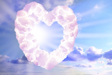 Image of Bright light shining through heart made of clouds in sky. Love of God, concept