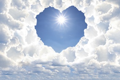 Image of Bright light shining in sky through heart shaped gap in clouds. Love of God, concept