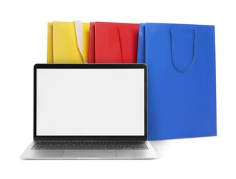 Image of Laptop and shopping bags isolated on white. Concept of online shopping, purchase via internet