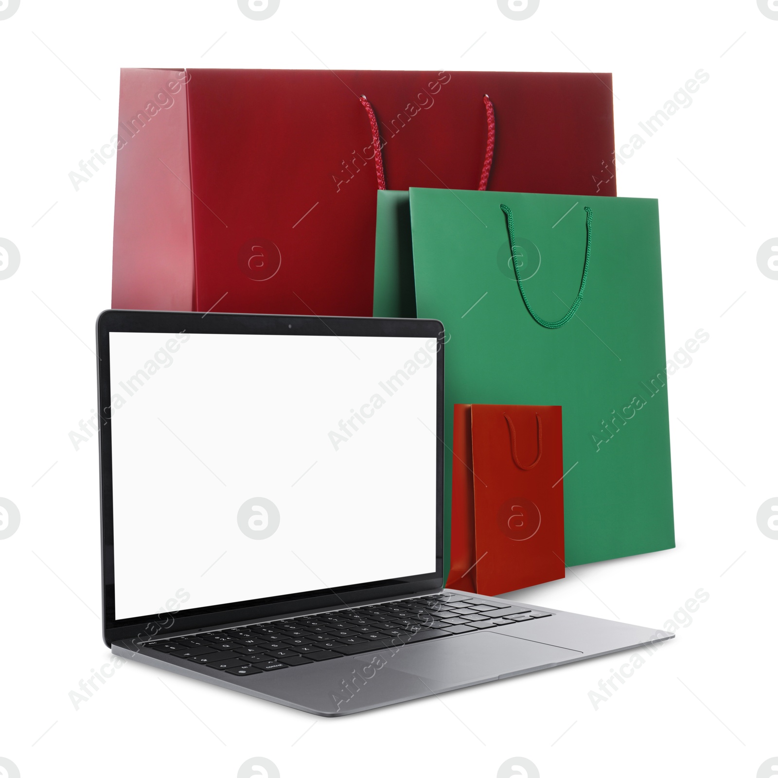 Image of Laptop and shopping bags isolated on white. Concept of online shopping, purchase via internet