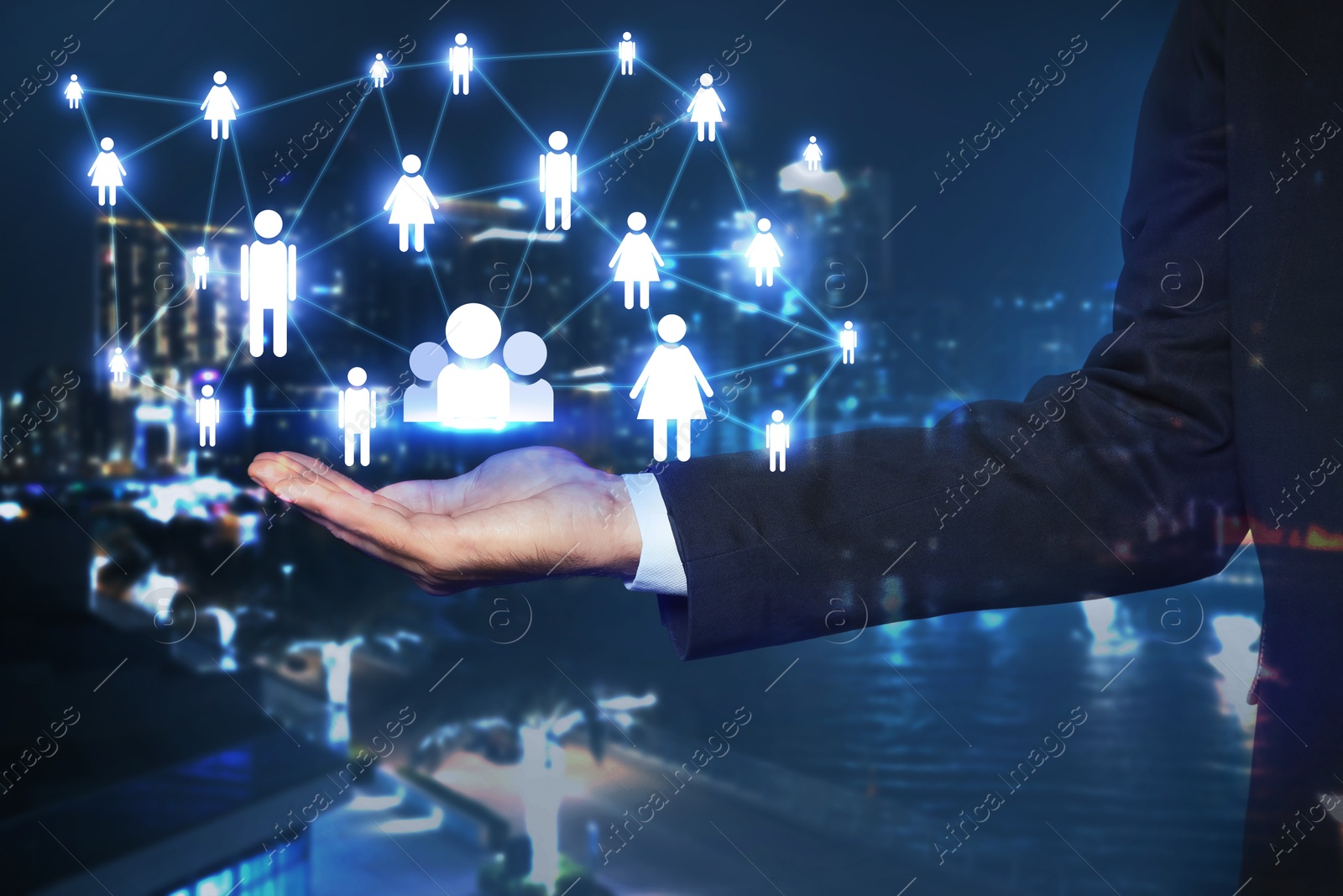 Image of Human resource. Businessman holding virtual scheme with people figures against night cityscape, closeup