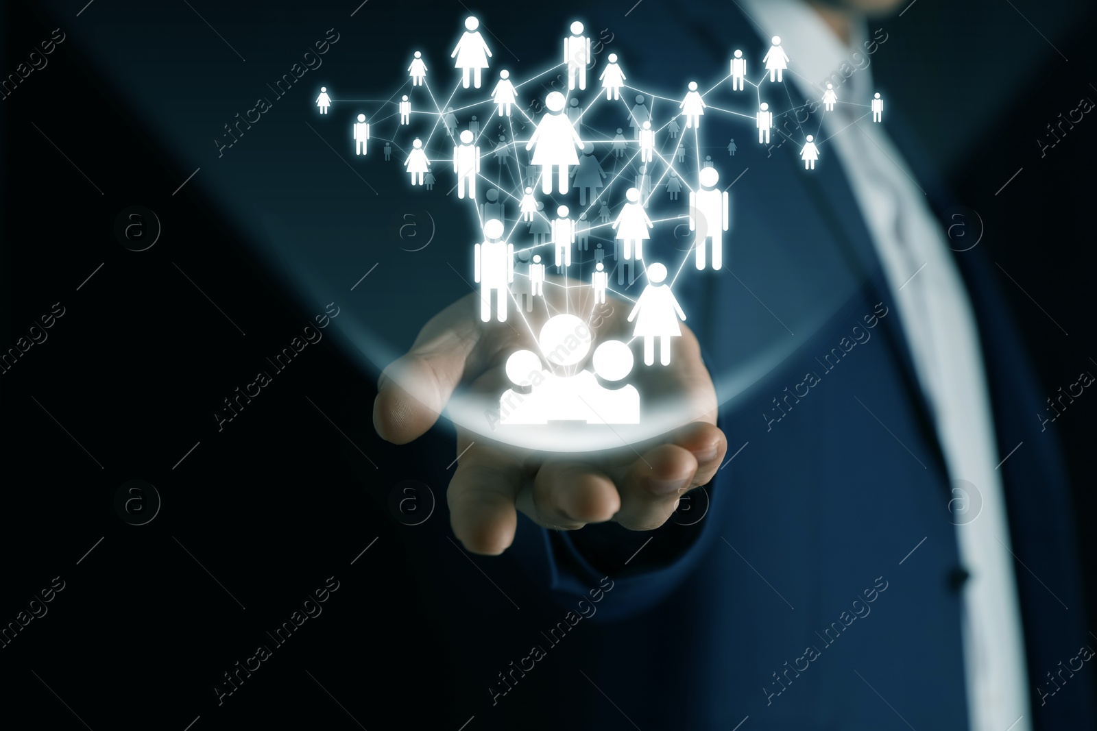 Image of Human resource. Businessman holding virtual scheme with people figures on black background, closeup