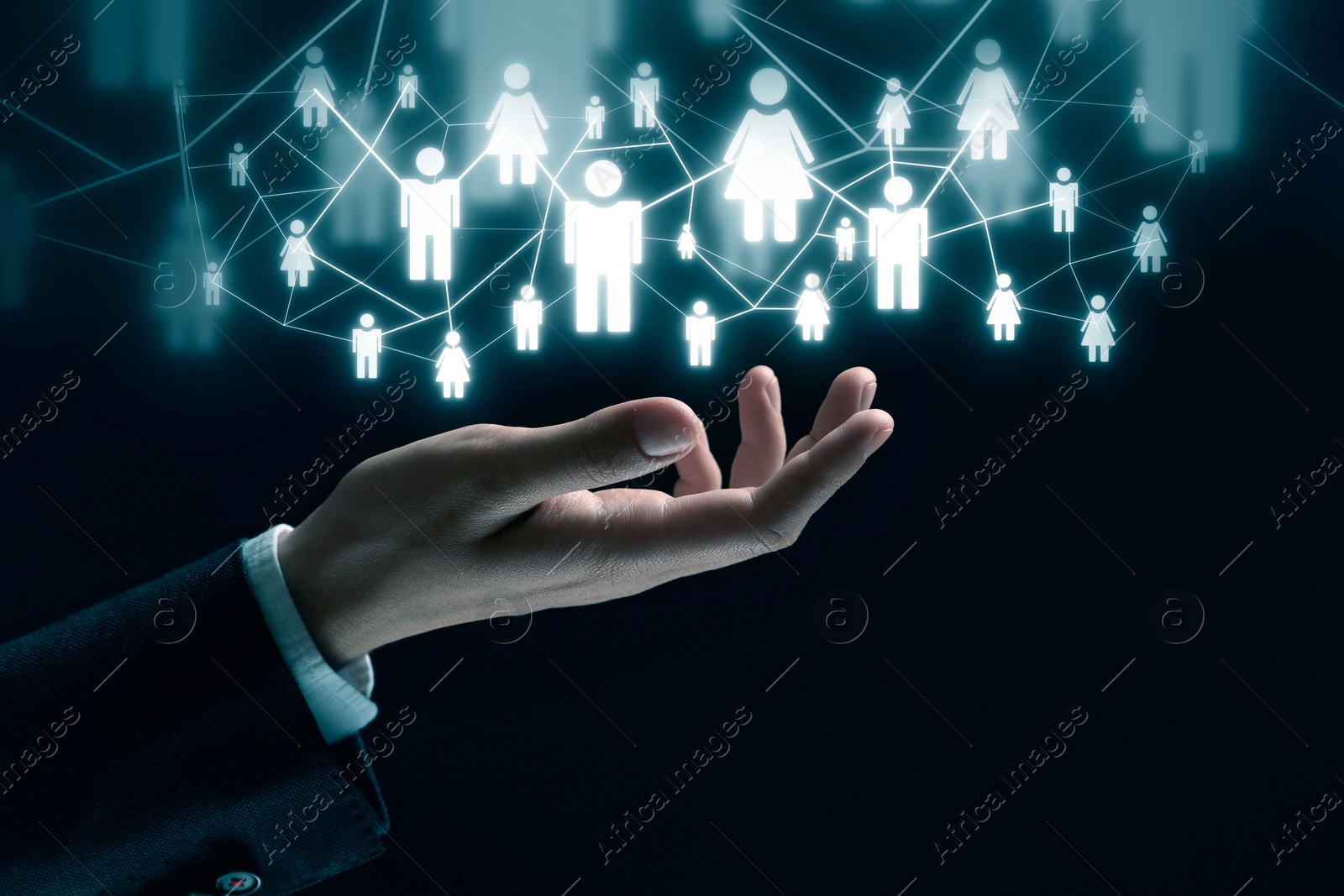 Image of Human resource. Businessman holding virtual scheme with people figures on black background, closeup