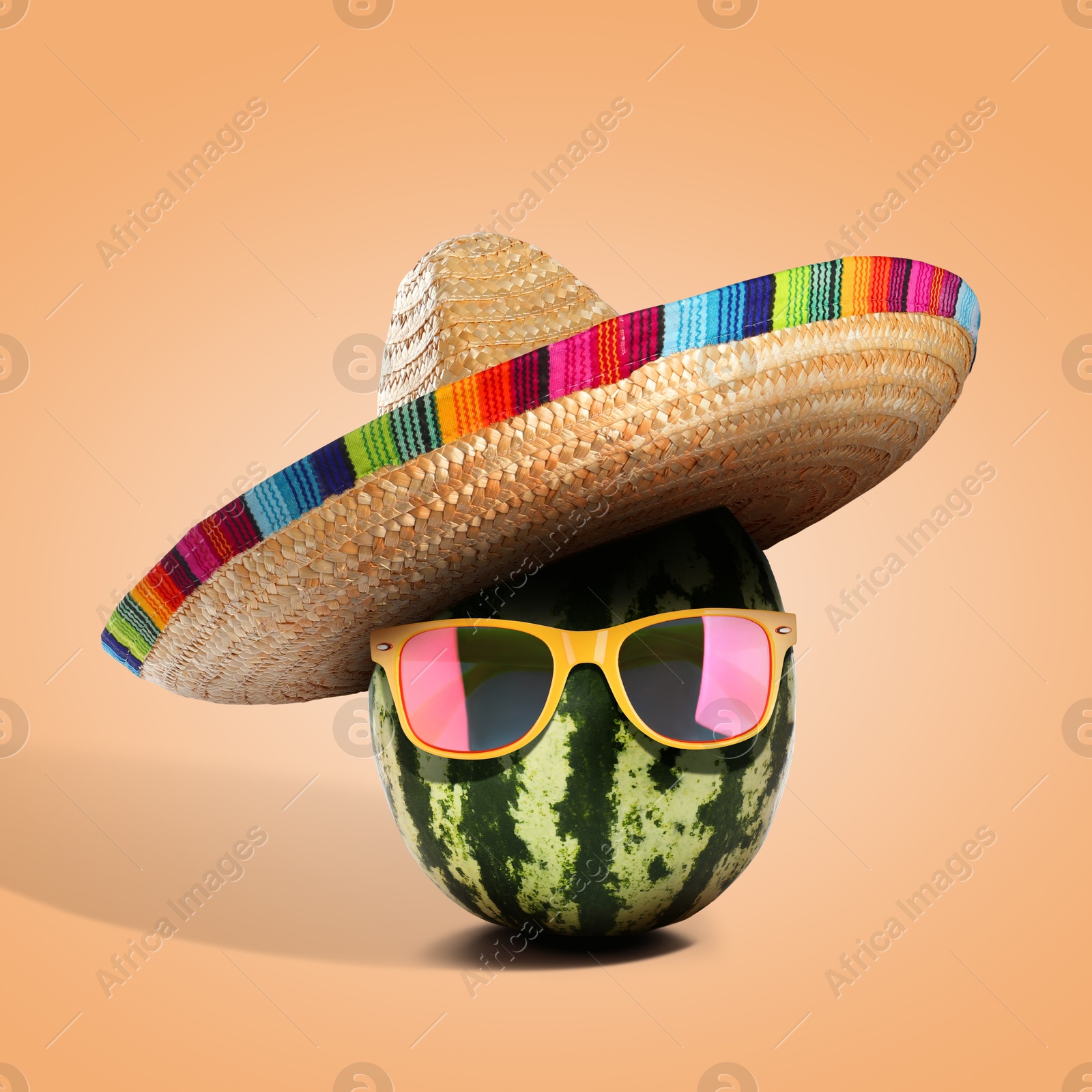 Image of Senor watermelon with Mexican sombrero hat and sunglasses on pale orange background