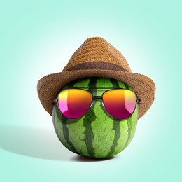 Image of Watermelon with straw hat and sunglasses on turquoise background