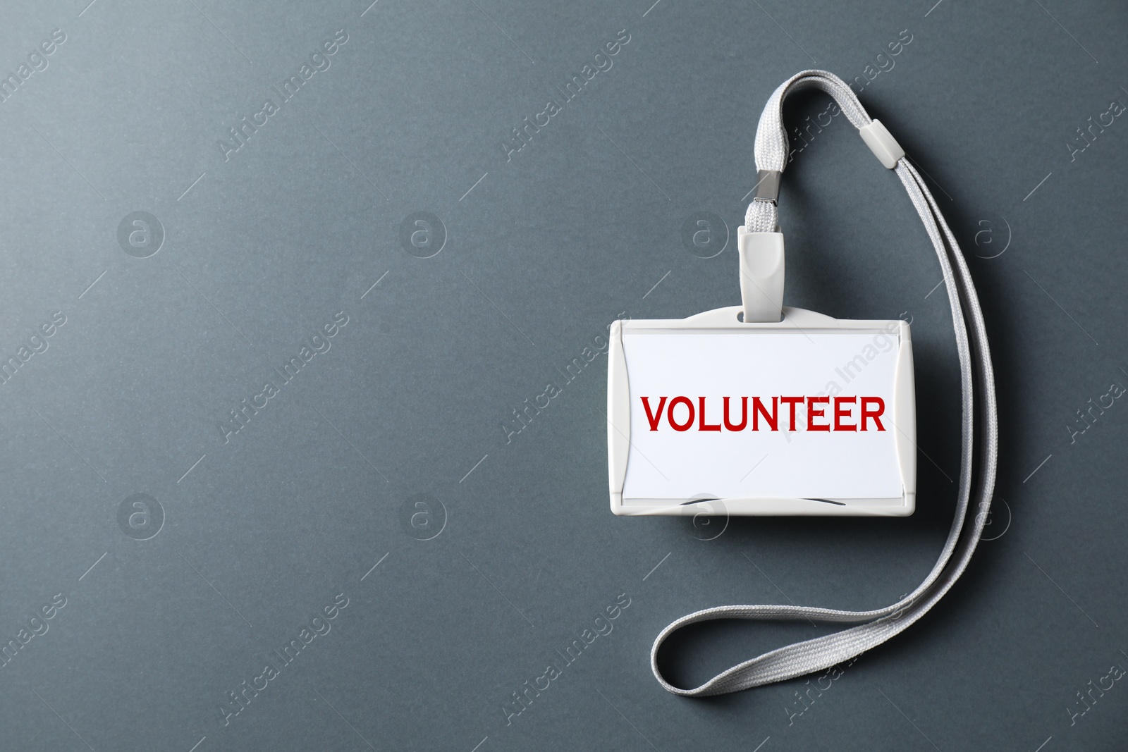 Image of Badge with word Volunteer on grey background, top view. Space for text