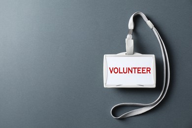 Image of Badge with word Volunteer on grey background, top view. Space for text