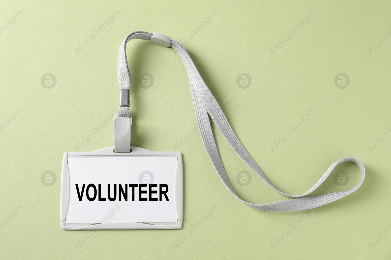 Image of Badge with word Volunteer on light green background, top view