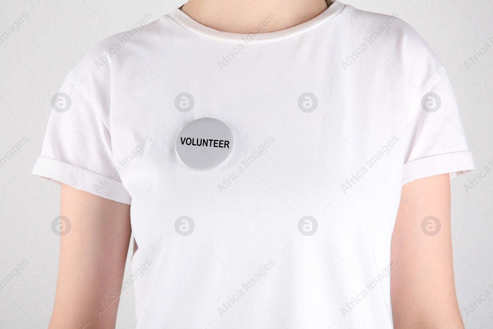 Image of Volunteer with button badge on white background, closeup