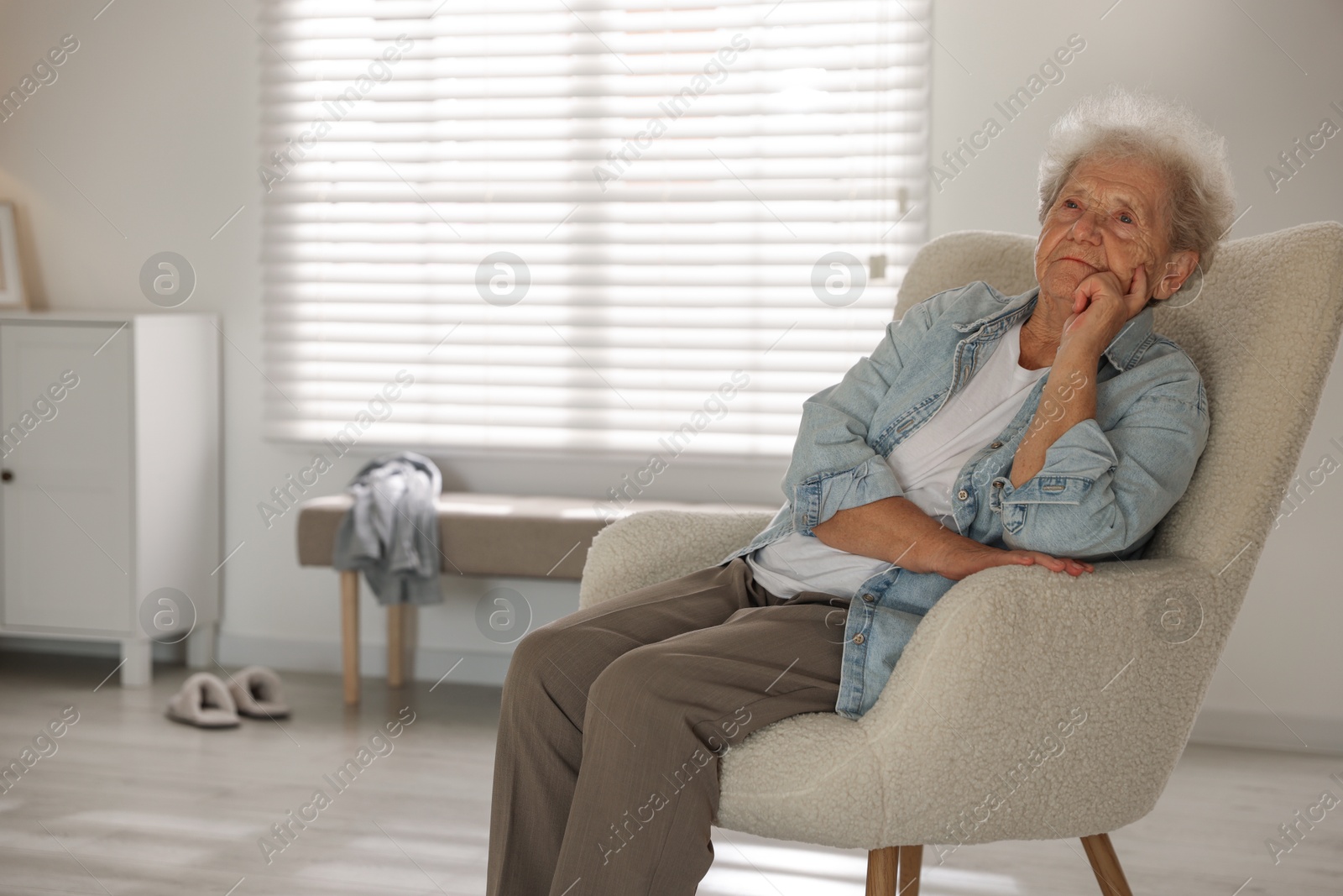 Photo of Loneliness concept. Sad senior woman sitting in armchair at home