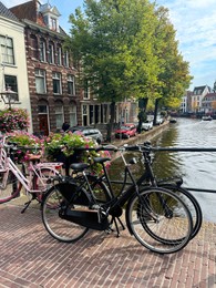 Photo of Modern bicycles parked near water canal in city