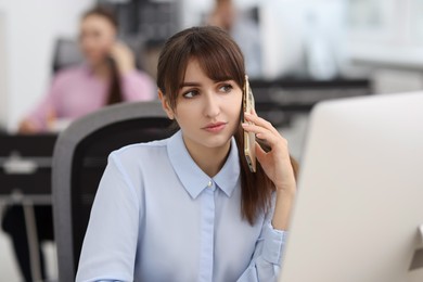 Photo of Saleswoman talking to client on phone in office