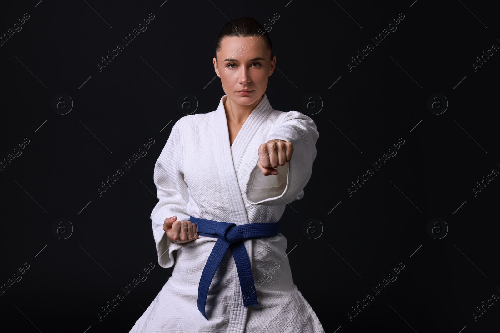 Photo of Karate fighter in kimono on black background