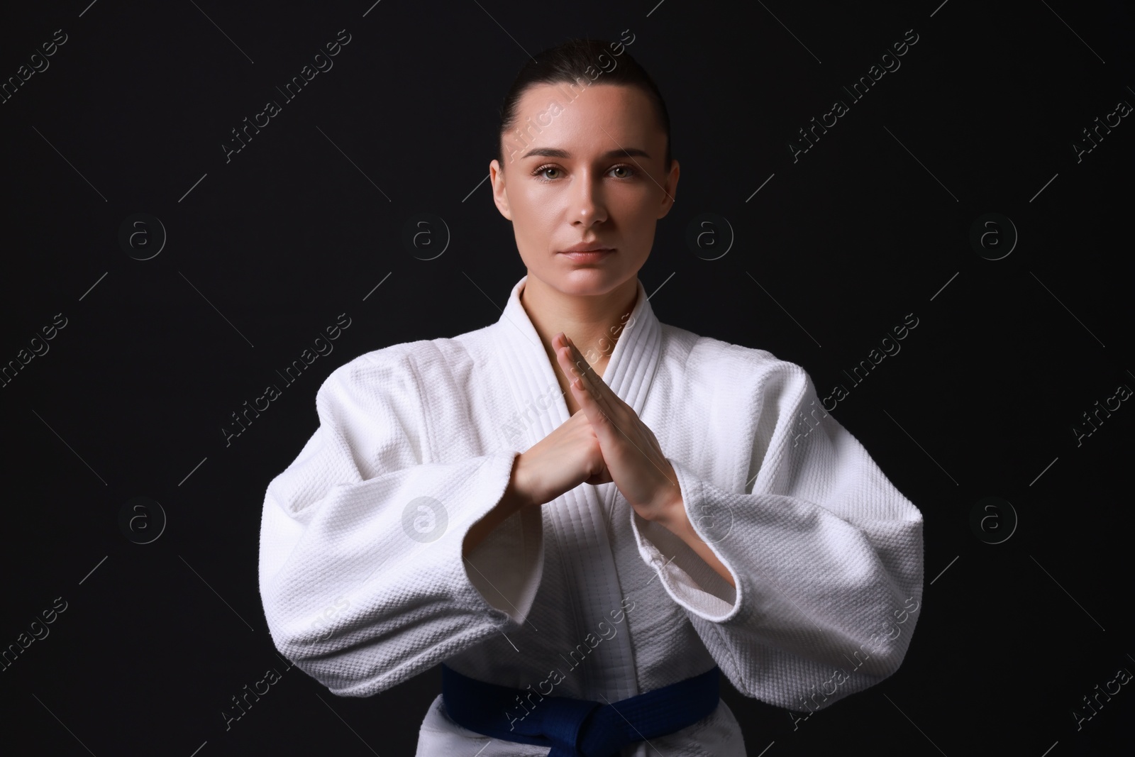 Photo of Karate fighter in kimono on black background