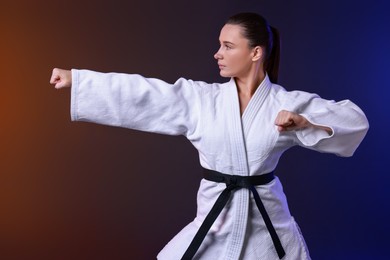 Photo of Karate fighter in kimono on color background