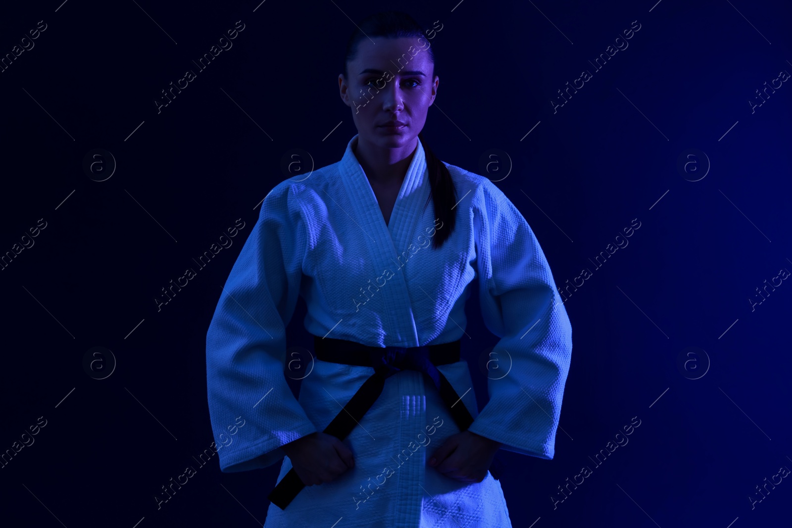 Photo of Karate fighter in kimono on dark background